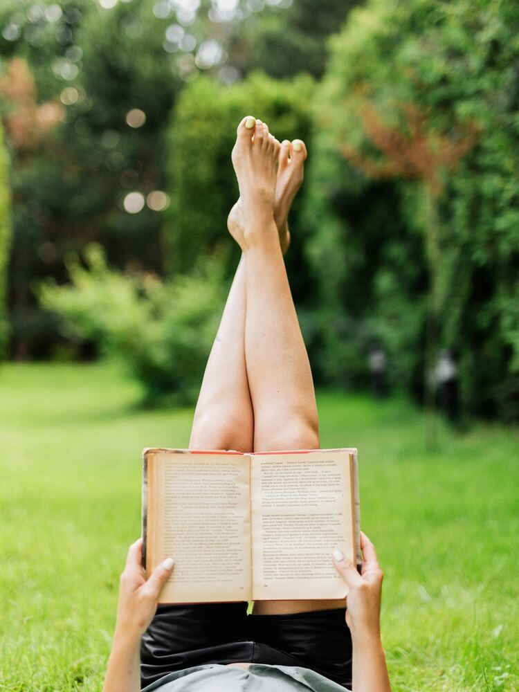 Mujer escribiendo en su diario en un jardín — momento de reflexión personal